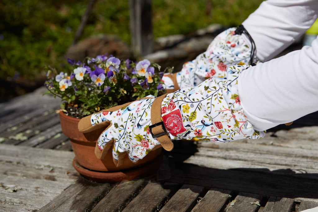 Barking Gardener Arm Saver Gloves with floral print, long cuffs, and synthetic leather palms gardening in a pot