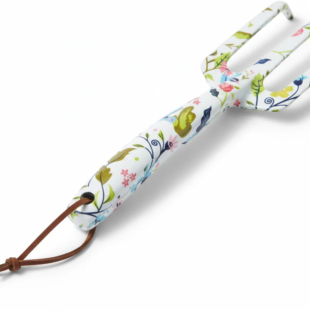 Barking Gardener hand cultivator with a white metal handle featuring a vibrant floral print and a leather hanging loop.