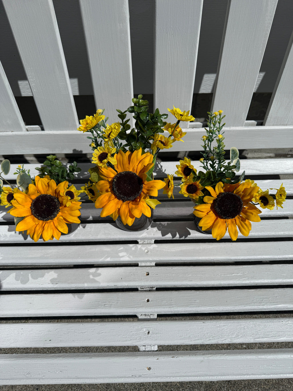 Barking Gardener farmhouse faux sunflower arrangements in custom mason jars on a white wooden bench