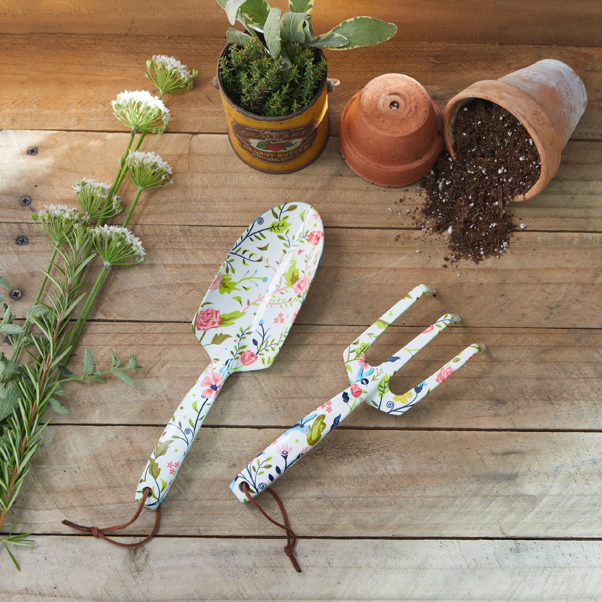 Barking Gardener floral print metal hand trowel and fork set with leather hanging loops on a rustic wooden table